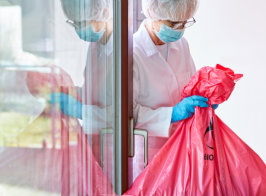 a nurse holding a medical disposable trash