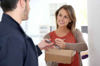 a man delivering a parcel to a woman at her doorstep