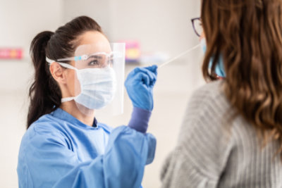 female aide performing a swab test to a woman